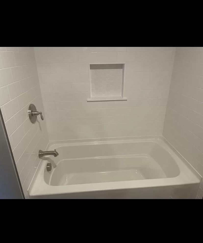 White subway tile tub surround with tiled niche
